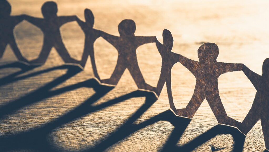 Human chain paper with light and shadow on wood table