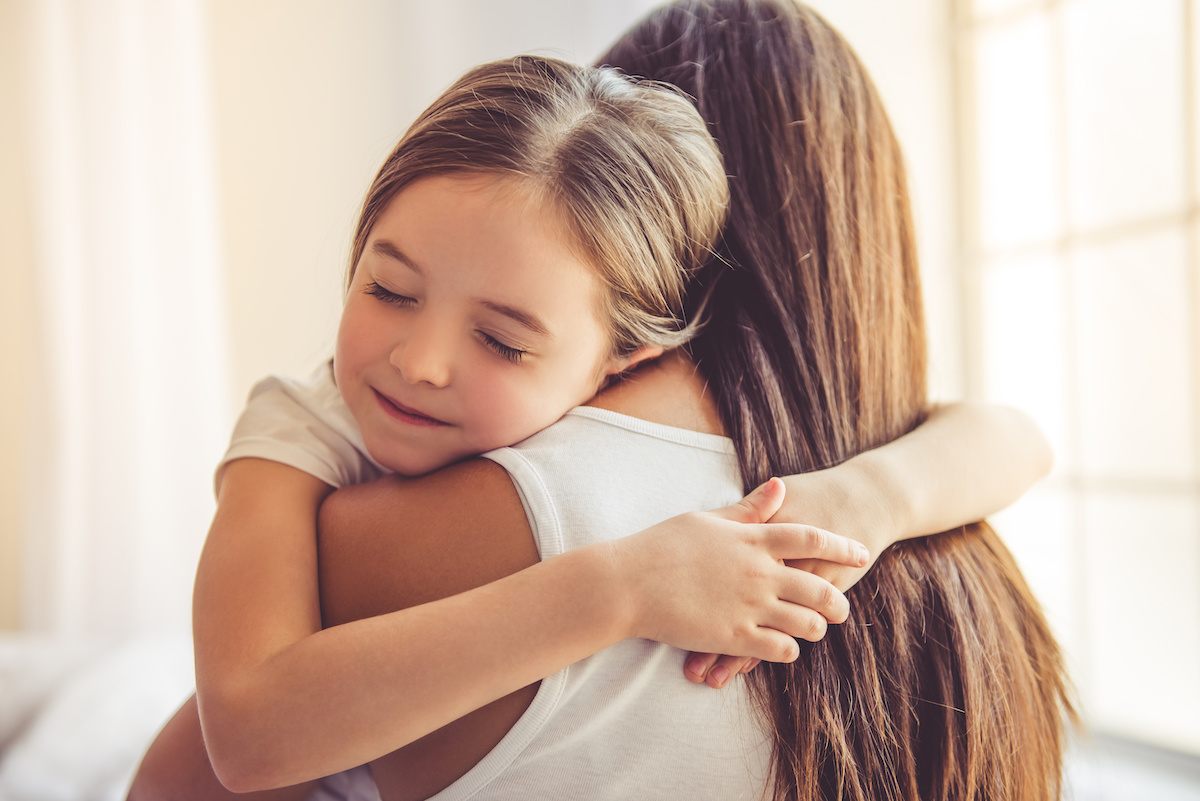 Young woman and her daughter hugging